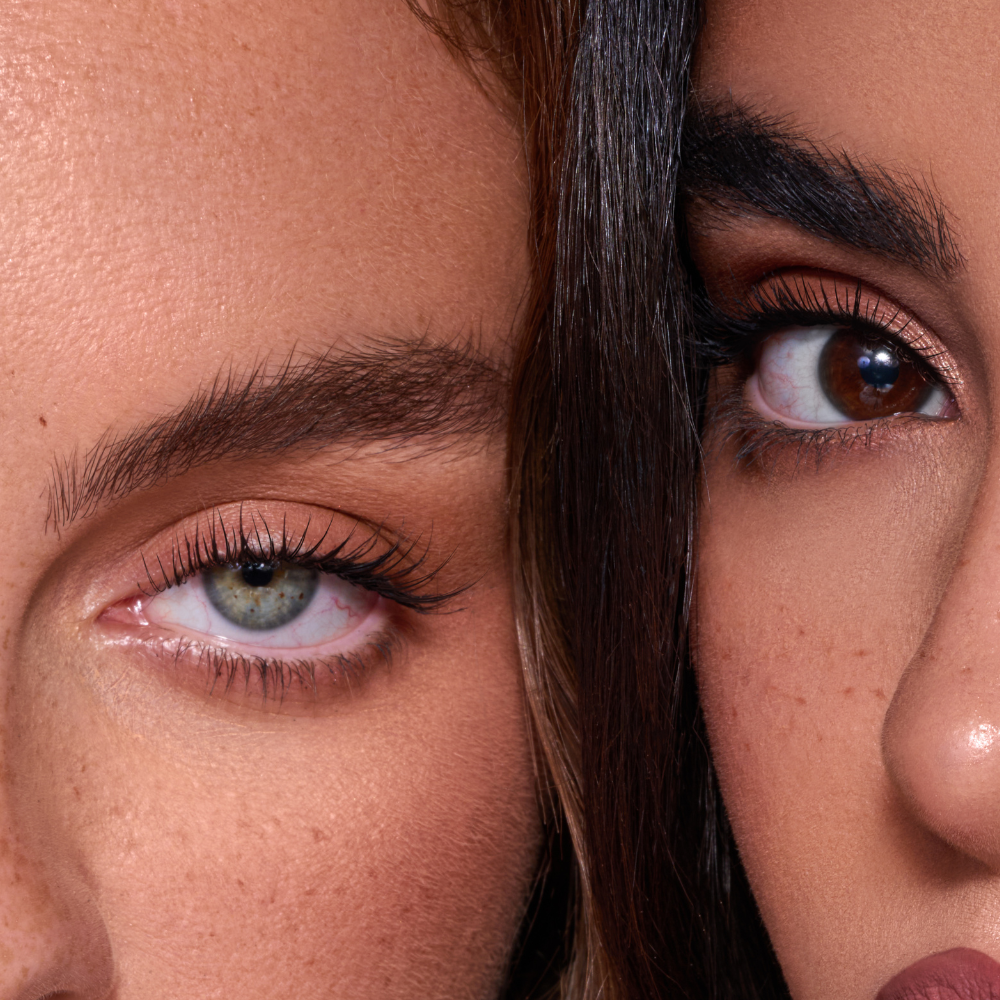 Wimpernserum und Serum für Augenbrauen auf einer gepflegten Kosmetikoberfläche neben einer Wimpernzange
