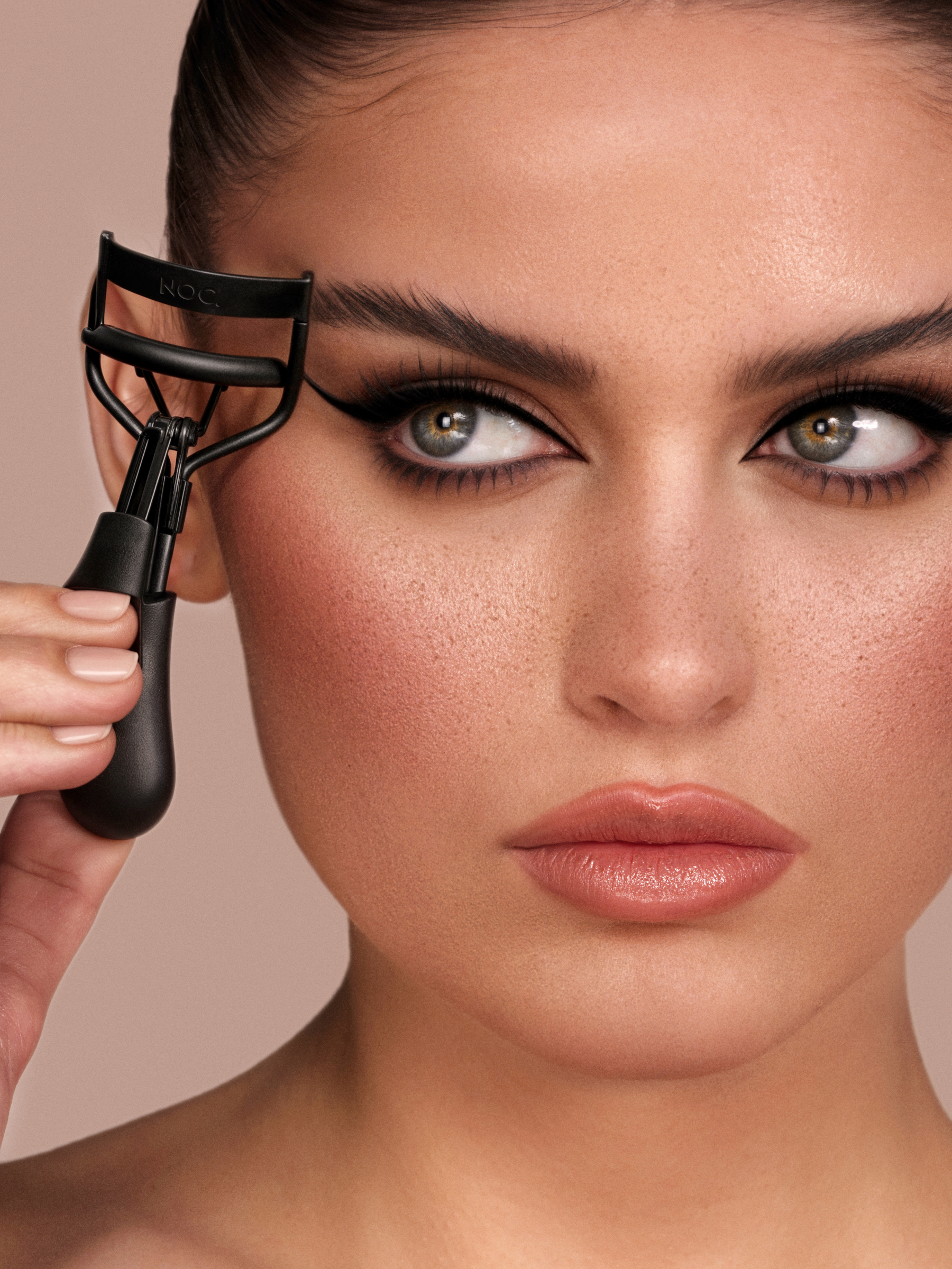 Elegante goldene Wimpernzange auf dunklem Hintergrund – beste Wimpernzange im Vergleich